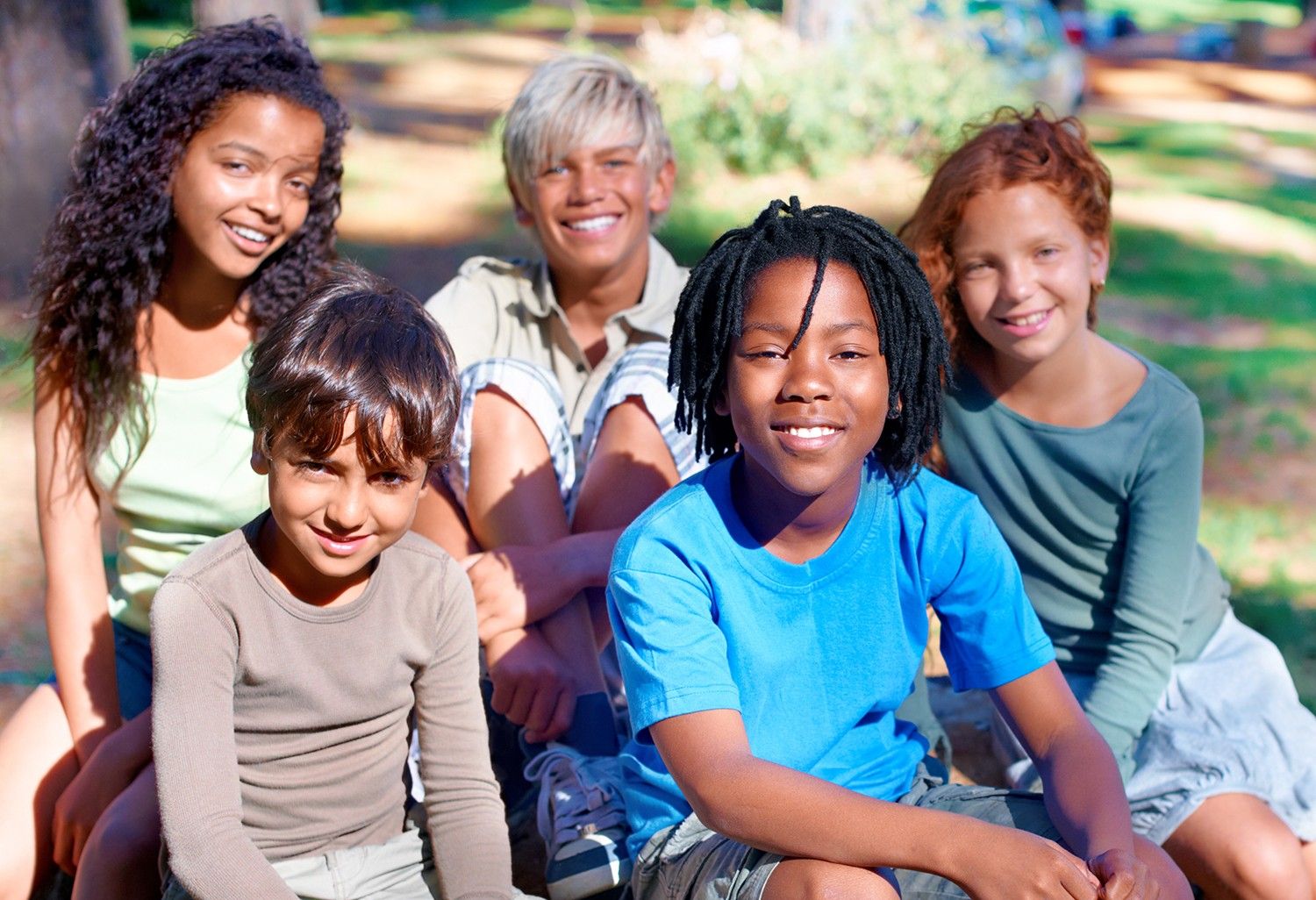 A group of people sitting in the grass.