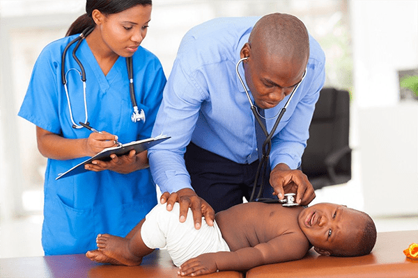 A doctor and nurse examining a baby.